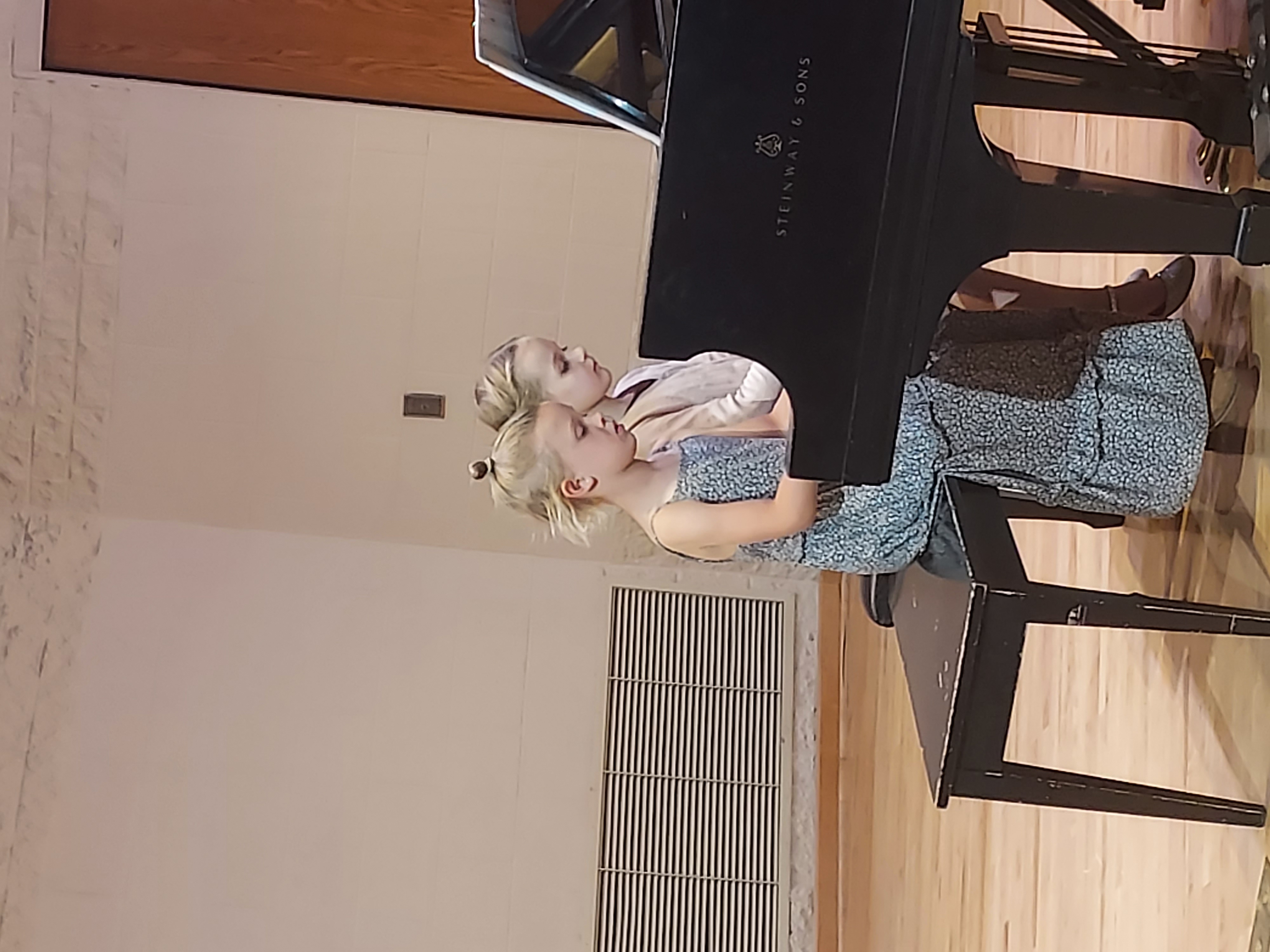 Picture of two girls playing the piano as a duet